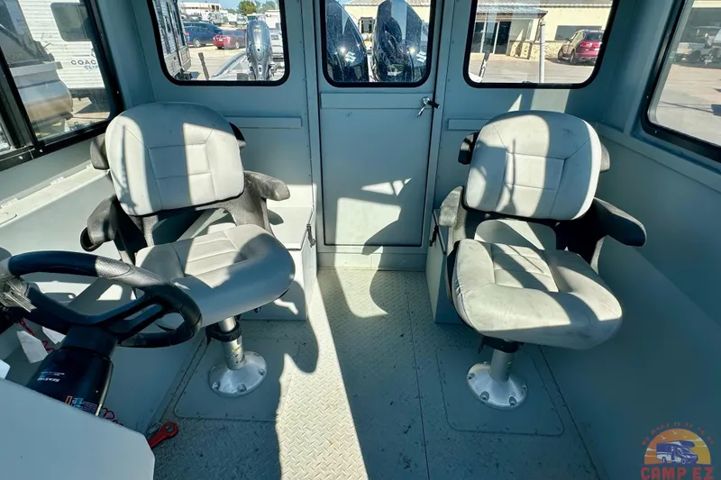 Slide: The Image of 2024 SeaArk 2672 Workhorse interior with two seats and steering wheel. - 21