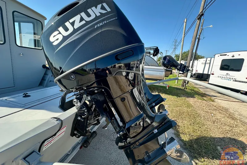 Slide: The Image of 2024 SeaArk 2672 Workhorse boat with Suzuki four-stroke outboard motor, parked outdoors. - 22