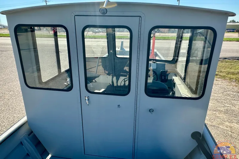 Slide: The Image of 2024 SeaArk 2672 Workhorse boat cabin with large windows and sturdy design. - 5