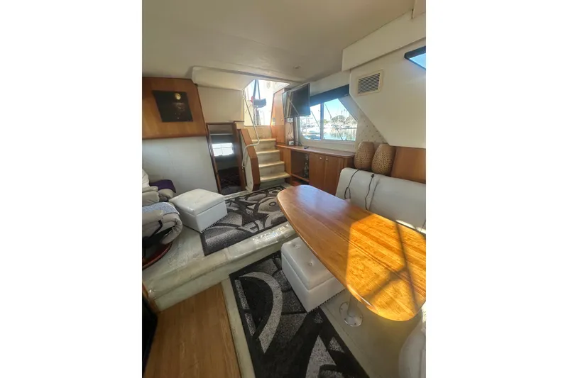 Slide: The Image of Interior of 2000 Silverton 38 yacht with cozy seating and wooden table. - 10