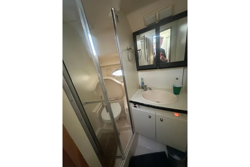 Slide: The Image of Bathroom interior of 2000 Silverton 38 yacht with shower, sink, and mirror cabinet. - 12