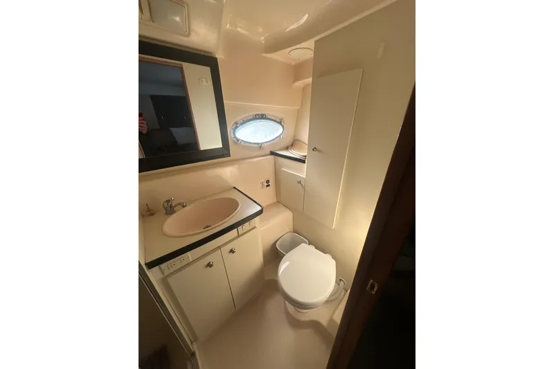 Slide: The Image of Bathroom interior of 2000 Silverton 38 yacht with sink, mirror, and toilet. - 16