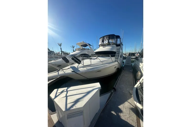 Slide: The Image of 2000 Silverton 38 yacht docked at marina under clear blue sky. - 2