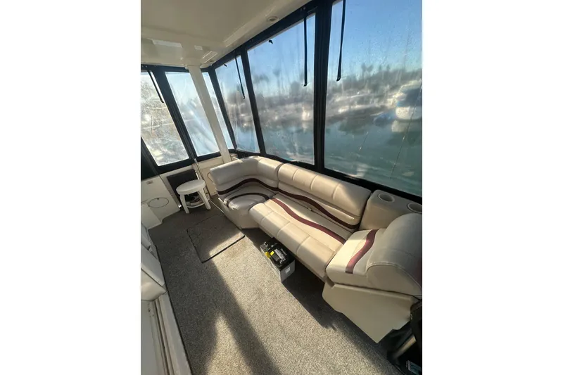 Slide: The Image of Interior of 2000 Silverton 38 boat with beige seating and large windows. - 3