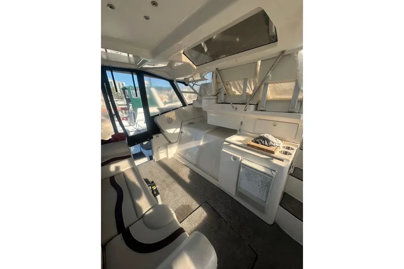 Slide: The Image of Interior of 2000 Silverton 38 yacht with seating, kitchenette, and windows. - 4