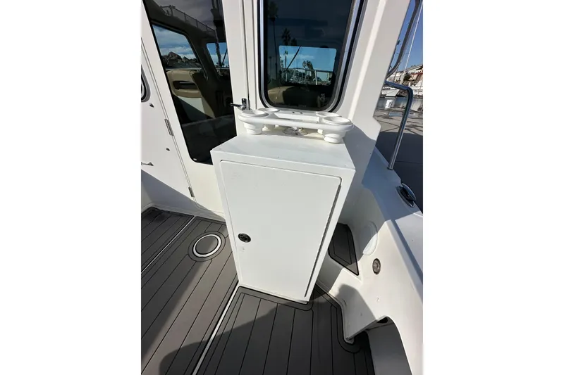 Slide: The Image of 2020 Parker 2320 Sport Cabin boat interior with storage compartment and window view. - 11