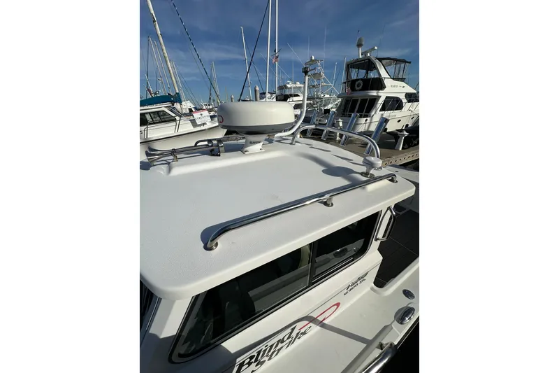 Slide: The Image of 2020 Parker 2320 Sport Cabin boat docked at marina with radar equipment. - 12