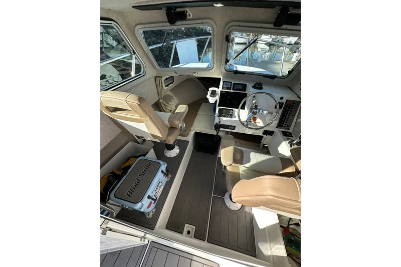 Slide: The Image of Interior of 2020 Parker 2320 Sport Cabin boat with steering wheel and seating. - 16