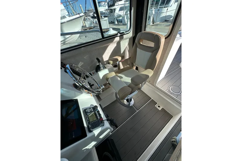 Slide: The Image of Interior of 2020 Parker 2320 Sport Cabin boat with steering wheel and seat. - 17
