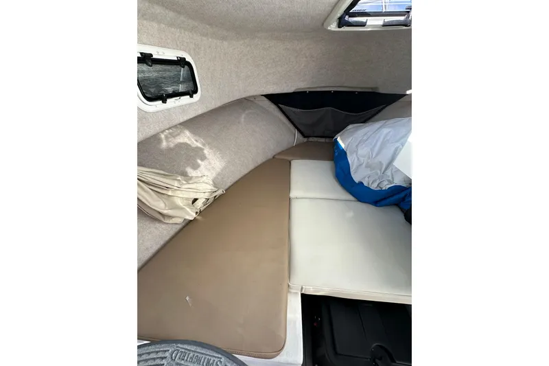 Slide: The Image of 2020 Parker 2320 Sport Cabin interior with cushioned seating and storage. - 20