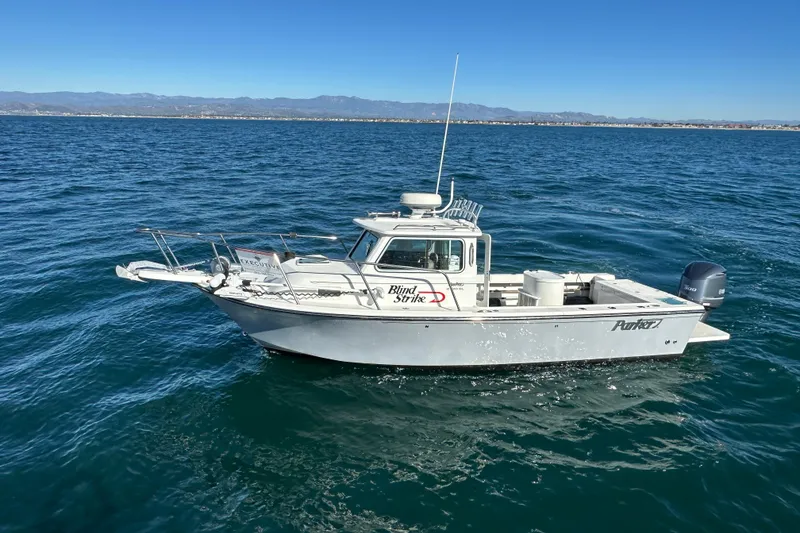 Slide: The Image of 2020 Parker 2320 Sport Cabin boat on open water, clear sky, distant mountains. - 4