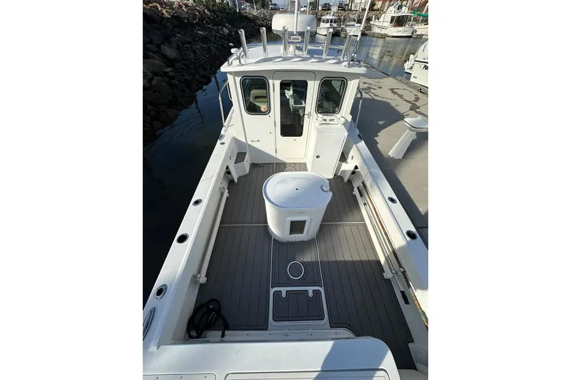 Slide: The Image of 2020 Parker 2320 Sport Cabin boat docked, featuring spacious deck and cabin. - 8