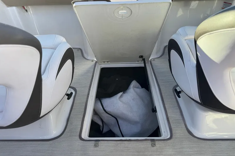 Slide: The Image of 2019 Chaparral 21 H2O Ski & Fish boat interior storage compartment between seats. - 21