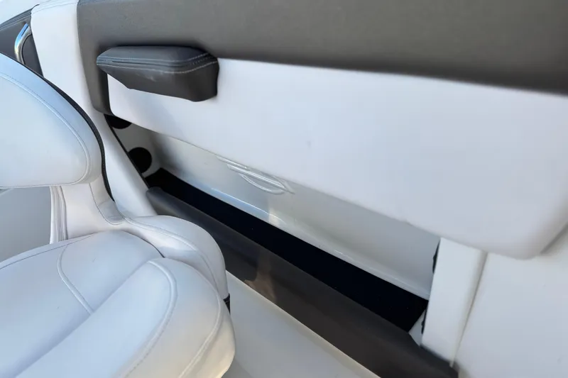 Slide: The Image of Interior of 2019 Chaparral 21 H2O Ski & Fish boat, featuring white seating and storage. - 23