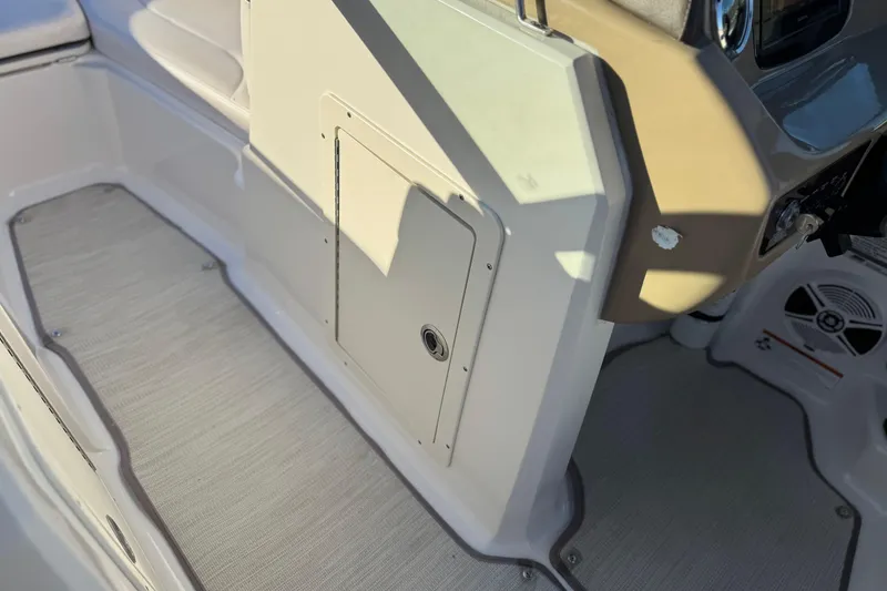 Slide: The Image of 2019 Chaparral 21 H2O Ski & Fish boat interior, featuring helm and storage compartment. - 32