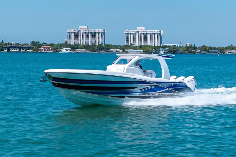Slide: The Image of 2026 Deep Impact 369 Sport boat on blue water with cityscape background. - 36