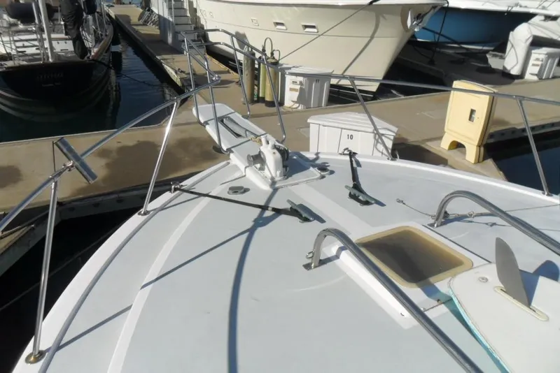 Slide: The Image of 1979 Bertram 46.6 Sport Fisher boat docked at marina, showing bow and deck details. - 12