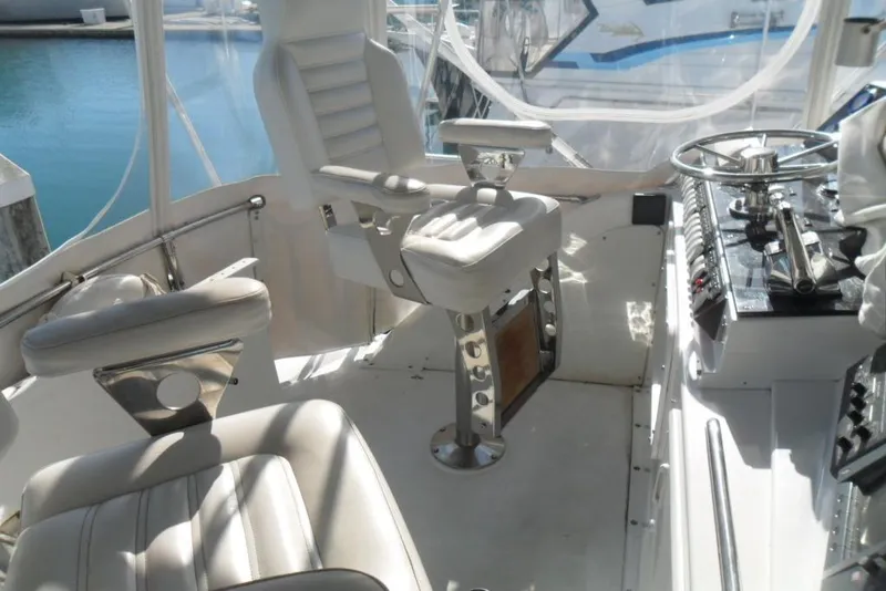 Slide: The Image of 1979 Bertram 46.6 Sport Fisher cockpit with white seating and control panel. - 14