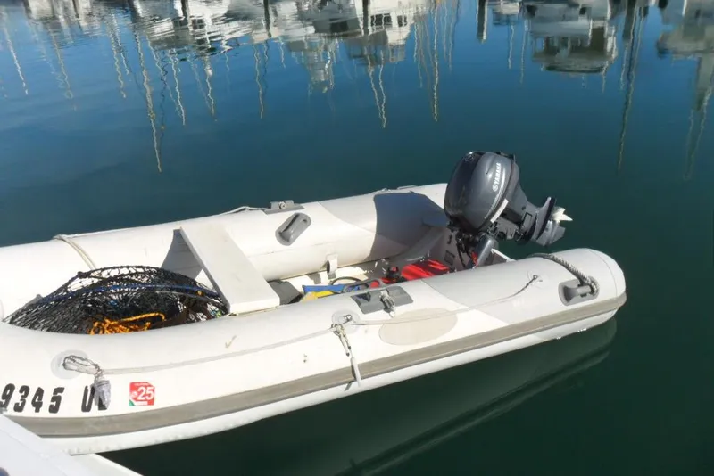 Slide: The Image of Inflatable boat with Yamaha motor docked on calm water, near Bertram 46.6 Sport Fisher. - 20