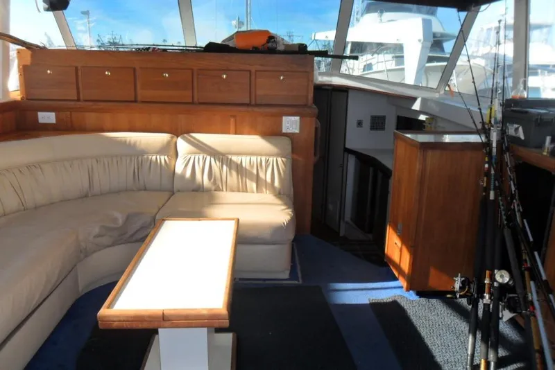 Slide: The Image of Interior of 1979 Bertram 46.6 Sport Fisher with seating, table, and fishing rods. - 21
