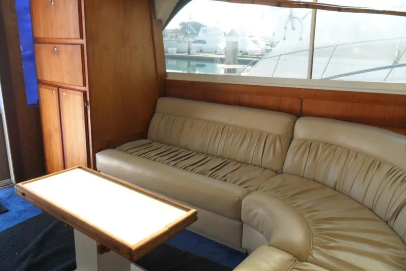 Slide: The Image of 1979 Bertram 46.6 Sport Fisher interior with beige leather seating and wooden cabinetry. - 22
