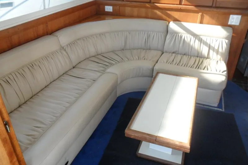 Slide: The Image of 1979 Bertram 46.6 Sport Fisher interior with beige leather seating and wooden table. - 23