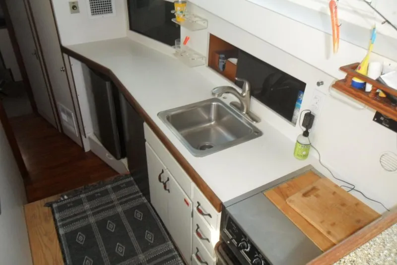 Slide: The Image of 1979 Bertram 46.6 Sport Fisher kitchen with sink, stove, and countertop. - 24