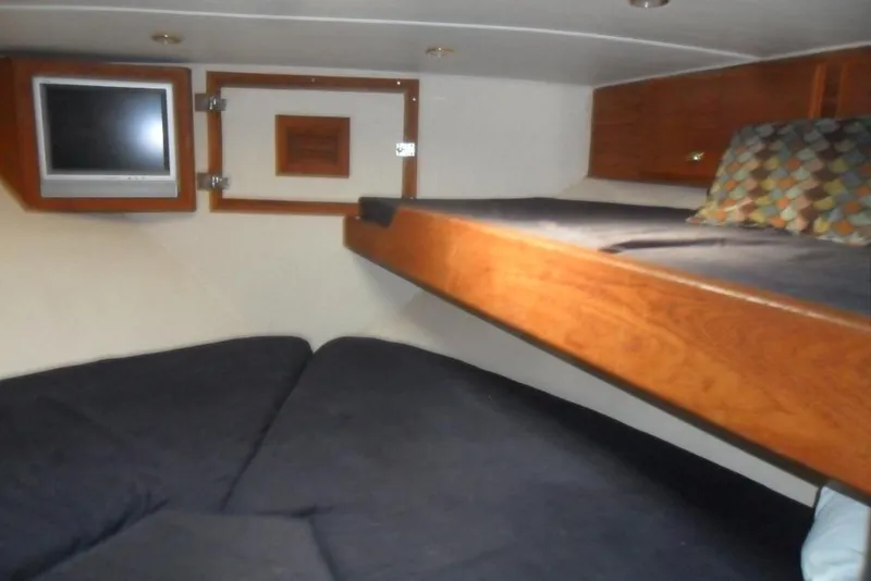 Slide: The Image of 1979 Bertram 46.6 Sport Fisher cabin interior with bunk beds and TV. - 31