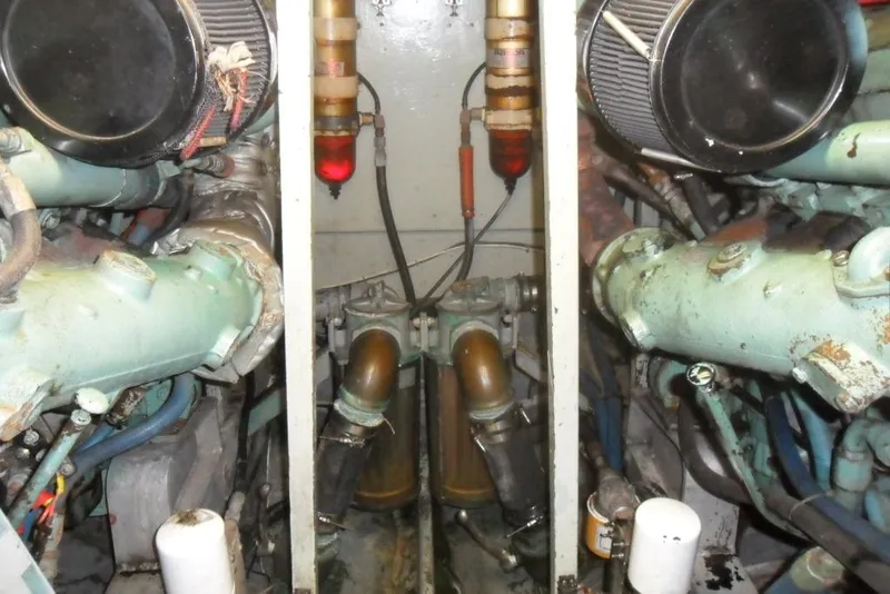 Slide: The Image of Engine room of a 1979 Bertram 46.6 Sport Fisher, showcasing dual engines and components. - 35