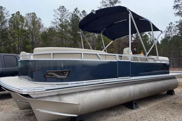 Slide: The Image of 2026 Tahoe Pontoon SPORT 2385 QUAD LOUNGE, blue and white, parked on gravel, with canopy. - 3