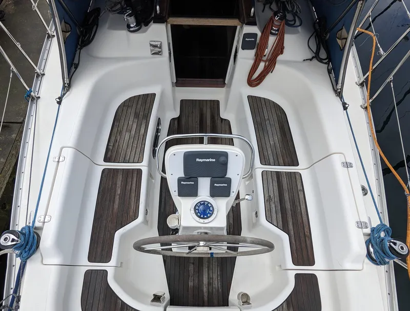 Slide: The Image of Cockpit of a 2001 Bavaria 34 yacht with steering wheel and wooden decks. - 3