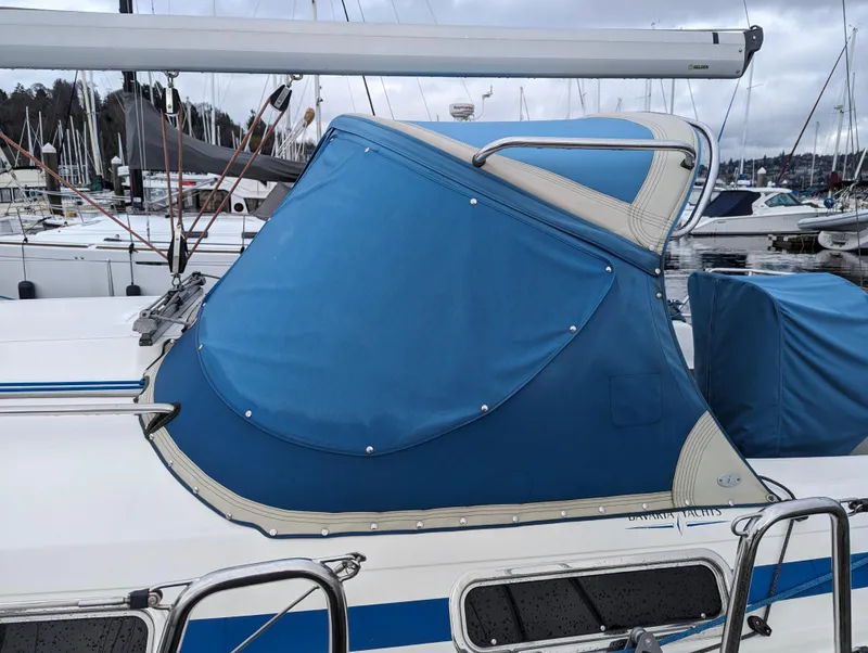 Slide: The Image of 2001 Bavaria 34 sailboat with blue cover docked in marina. - 5