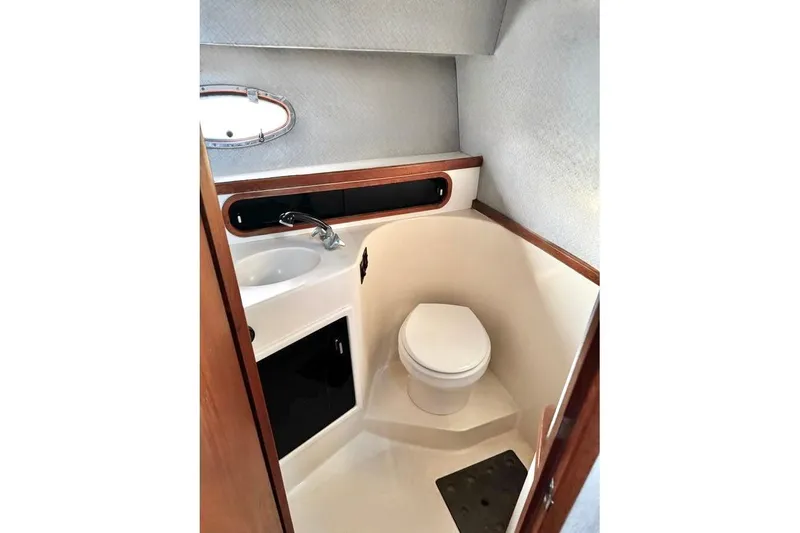 Slide: The Image of Compact bathroom in a 1990 Tiara Open boat, featuring a toilet and sink. - 4