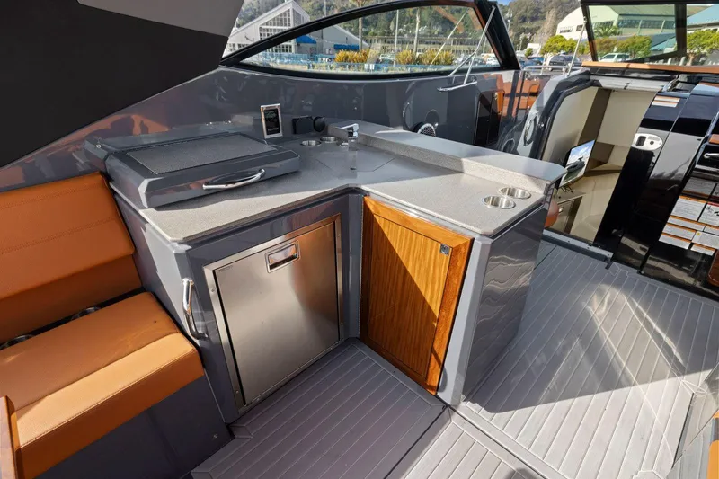 Slide: The Image of 2022 Cruisers Yachts 38 GLS South Beach IO interior with kitchenette and seating area. - 15