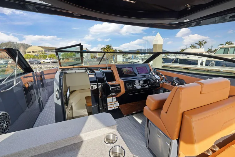 Slide: The Image of 2022 Cruisers Yachts 38 GLS South Beach IO cockpit with modern controls and luxurious seating. - 19