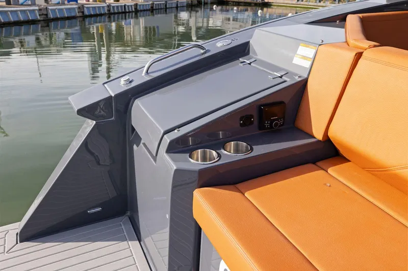 Slide: The Image of 2022 Cruisers Yachts 38 GLS South Beach IO with orange seating and cup holders by the water. - 12