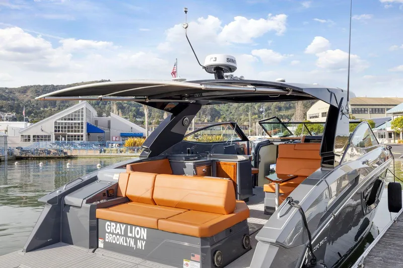 Slide: The Image of 2022 Cruisers Yachts 38 GLS South Beach IO with orange seating, docked in a marina. - 9