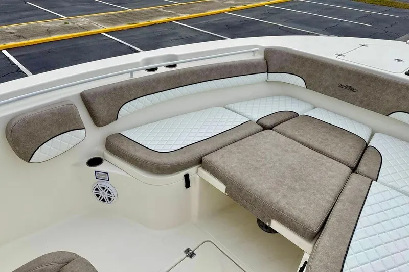 Slide: The Image of 2016 NauticStar 28 XS boat interior with cushioned seating and speaker. - 12