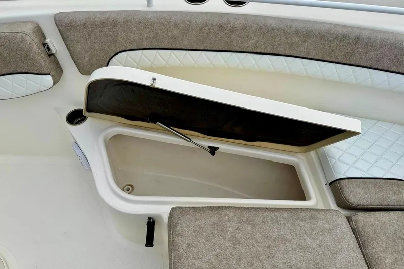 Slide: The Image of 2016 NauticStar 28 XS boat interior storage compartment with cushioned seating. - 16