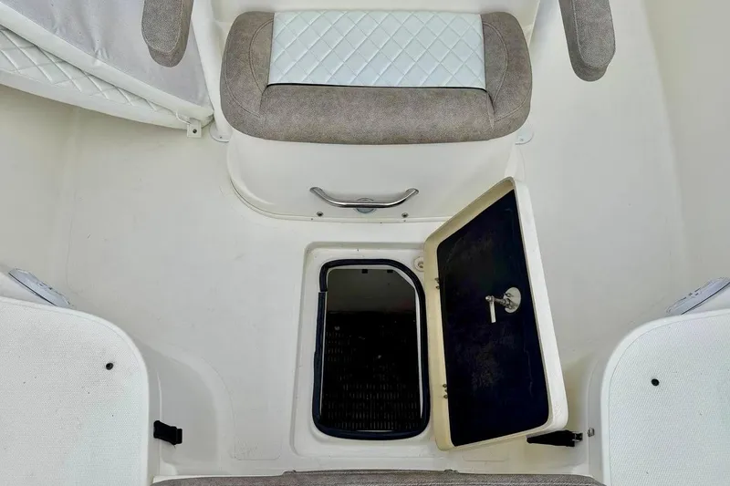 Slide: The Image of 2016 NauticStar 28 XS boat interior with open storage compartment and cushioned seating. - 17
