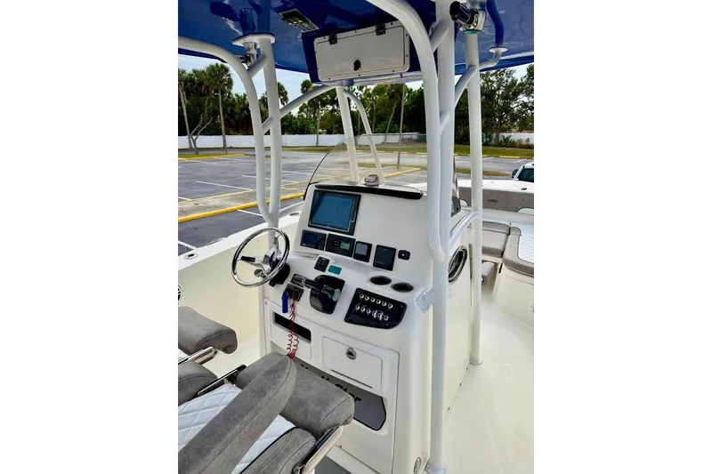 Slide: The Image of 2016 NauticStar 28 XS boat cockpit with steering wheel and control panel. - 19