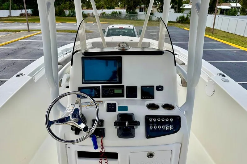 Slide: The Image of 2016 NauticStar 28 XS boat console with steering wheel and navigation equipment. - 21