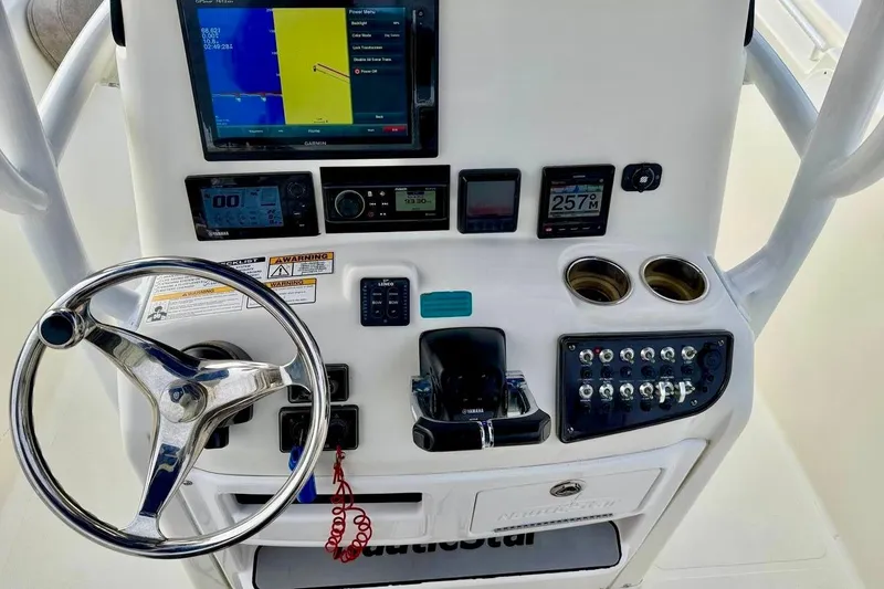 Slide: The Image of Control panel of a 2016 NauticStar 28 XS boat with steering wheel and navigation instruments. - 22