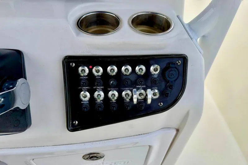Slide: The Image of Control panel of a 2016 NauticStar 28 XS boat with switches and cup holders. - 27