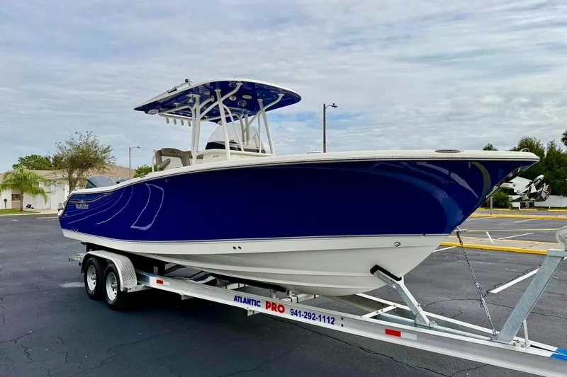 Slide: The Image of 2016 NauticStar 28 XS boat on trailer, blue hull, parked outdoors. - 3