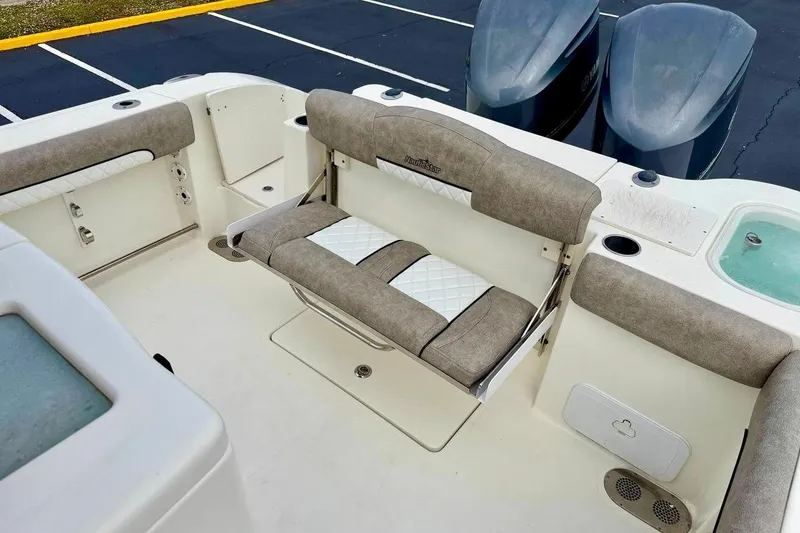 Slide: The Image of 2016 NauticStar 28 XS boat interior with cushioned seating and twin engines. - 34