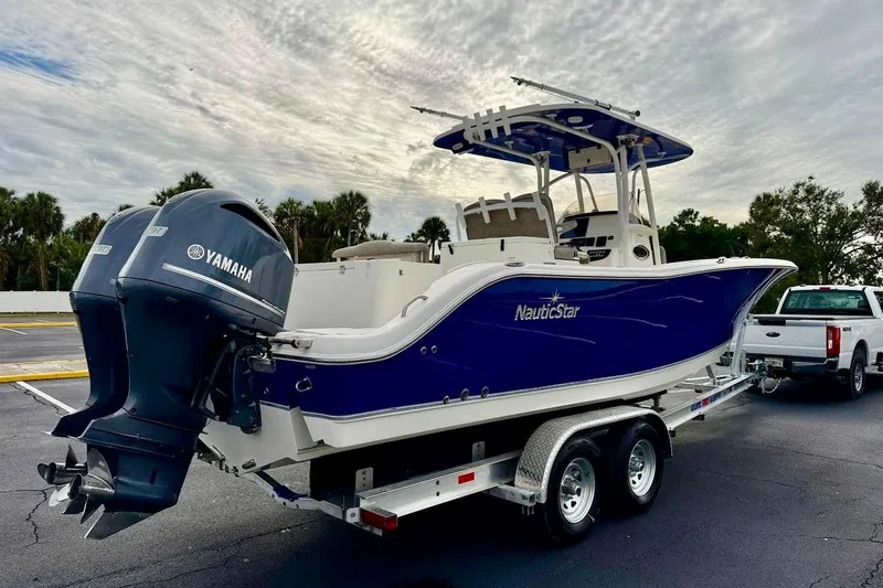 Slide: The Image of 2016 NauticStar 28 XS boat on trailer with Yamaha engines, parked outdoors. - 5