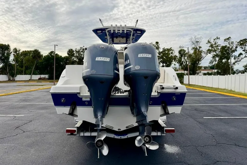 Slide: The Image of 2016 NauticStar 28 XS boat with dual Yamaha engines in a parking lot. - 6