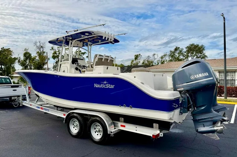Slide: The Image of 2016 NauticStar 28 XS boat with Yamaha engine on trailer, parked outdoors. - 7