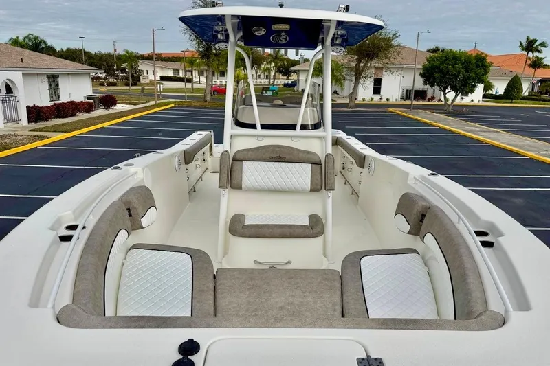 Slide: The Image of 2016 NauticStar 28 XS boat interior with cushioned seating in a parking lot. - 9
